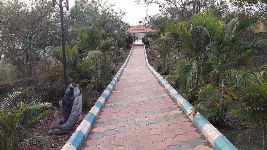 Tiled walkway lined with palms leading to a gazebo at Nrupatunga Betta, Hubli.