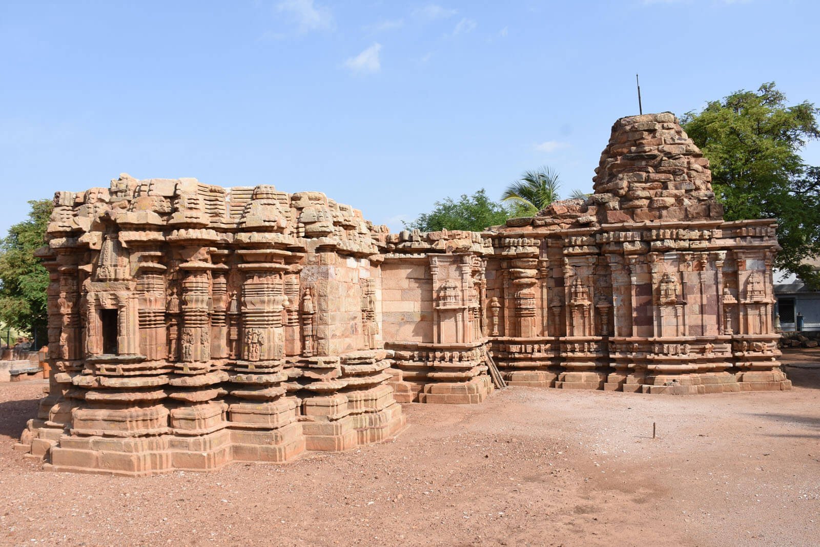 Exterior of Banashankari Temple, Amargol — reddish sandstone walls, niches, and stepped shikhara in Chalukyan style.