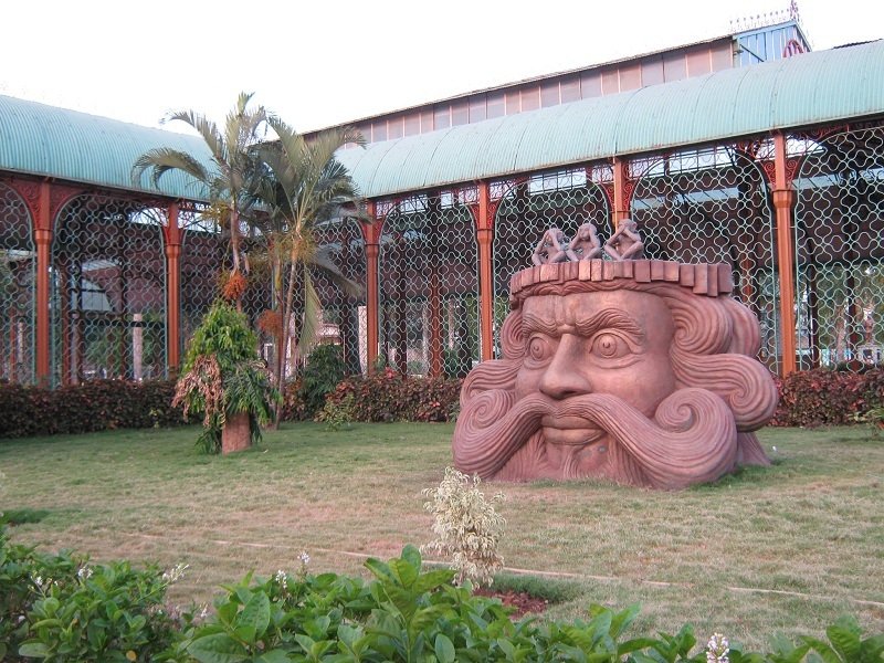 Face sculpture and the glass conservatory building at Indira Gandhi Glass House Garden, Hubli.